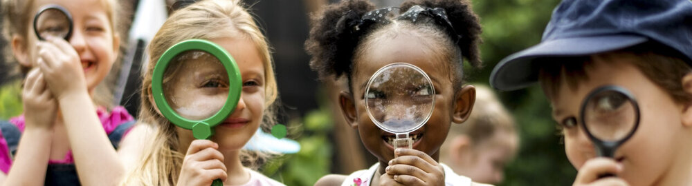 © iStock.com/Rawpixel Gruppe des Kindergartens Kinder Freunde halten Lupe für erforschen
