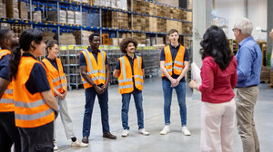 © iStock.com/alvarez Reifer Geschäftsmann und Geschäftsfrau treffen sich mit Lagermitarbeitern