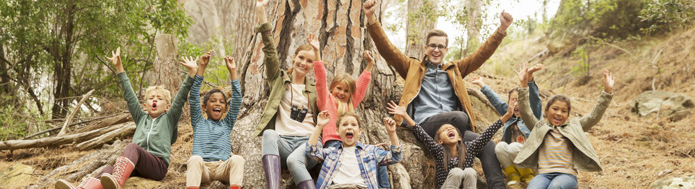© iStock.com/Caiaimage/Robert Daly Schüler und Lehrer jubeln im Wald