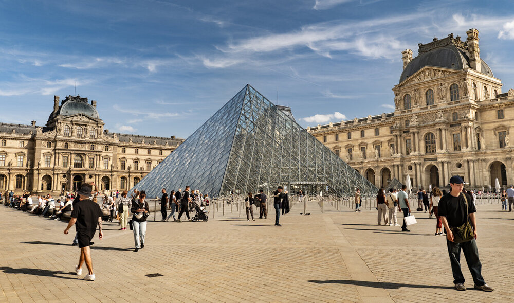 © iStock.com/Pgiam Touristen in Paris, Frankreich, versammeln sich am Eingang des Louvre-Museums